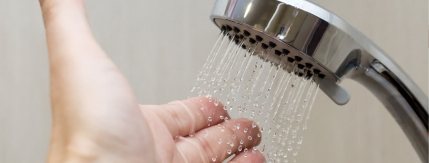hand under shower spray to test temperature