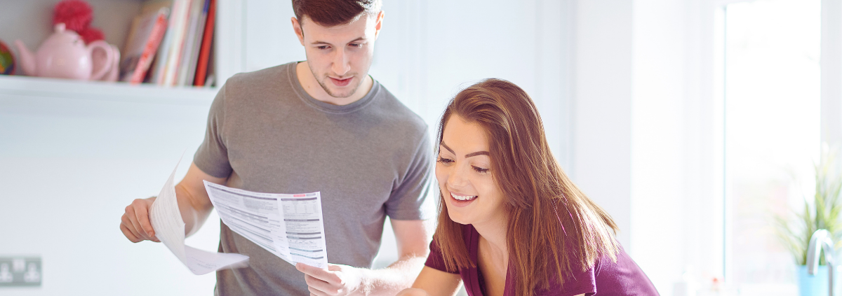 A couple at a laptop happily paying their lower power bills